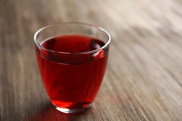 A glass of tasty garnet juice, on wooden background — Stock Photo, Image