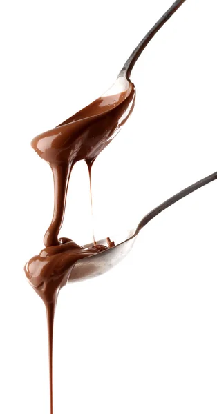 Chocolate con leche derretida vertiendo de cucharas, aislado sobre blanco — Foto de Stock