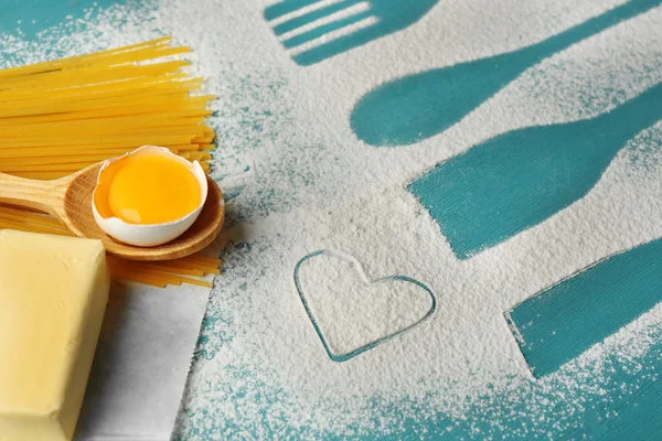 Heart of flour and pasta on color wooden background — Stock Photo, Image