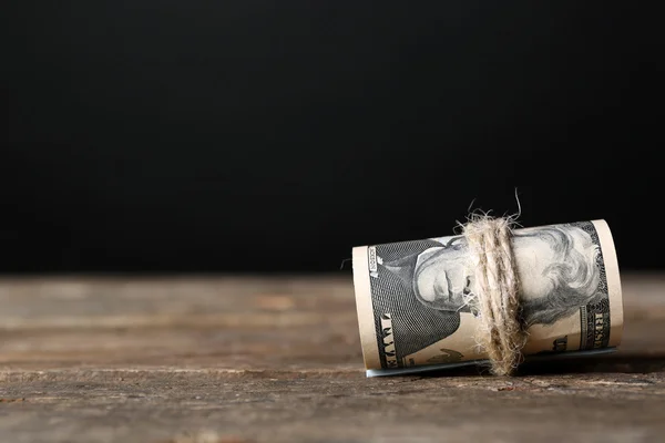 Dólares rolam na mesa de madeira — Fotografia de Stock