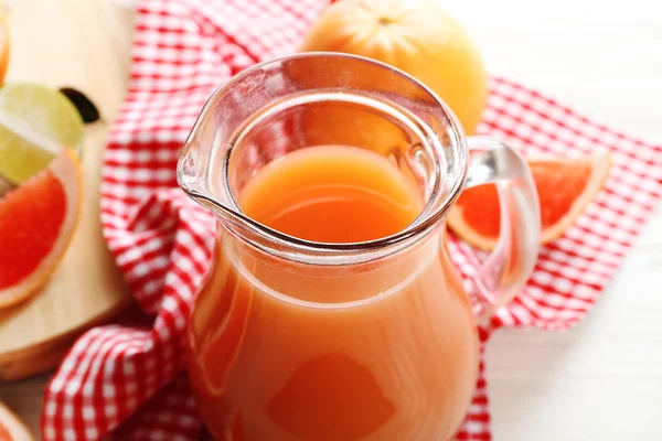Sebotol jus jeruk dan buah-buahan segar pada latar belakang kayu muda — Stok Foto