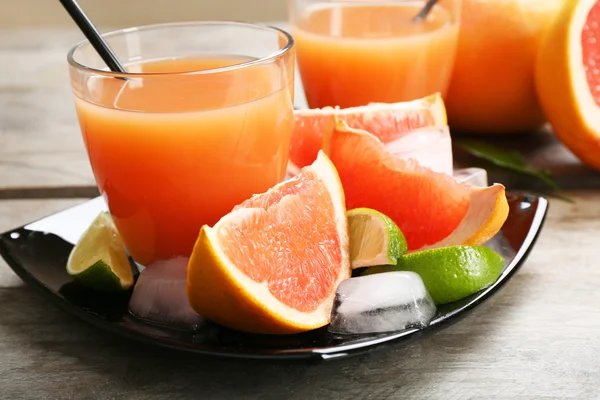 Jus jeruk dan buah segar di piring hitam — Stok Foto