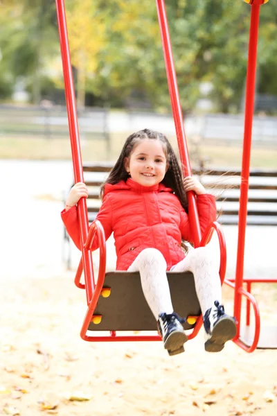 Meisje op schommel in stadspark — Stockfoto