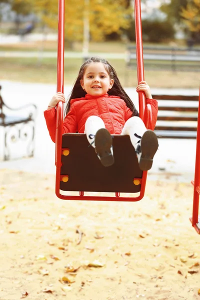 Meisje op schommel in stadspark — Stockfoto