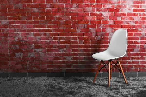 Sedia moderna su muro di mattoni — Foto Stock