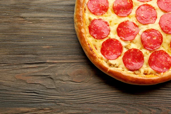 Gustosa pizza con salame su fondo di legno, primo piano — Foto Stock