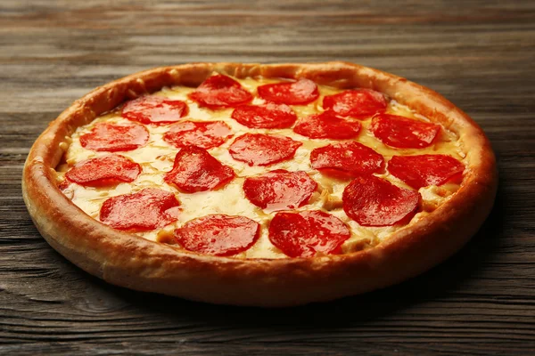 Smaklig pizza med salami på trä bakgrund — Stockfoto