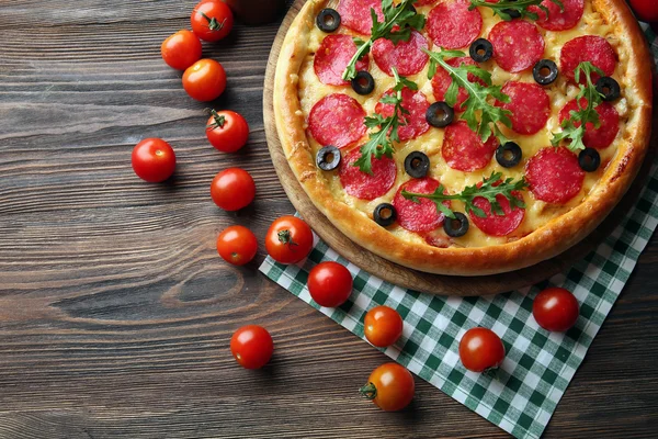 Gustosa pizza con salame sul tavolo di legno decorato — Foto Stock