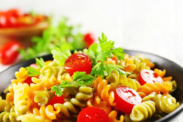 Prato de macarrão delicioso em tigela preta em mesa de madeira cinza servida, close-up — Fotografia de Stock