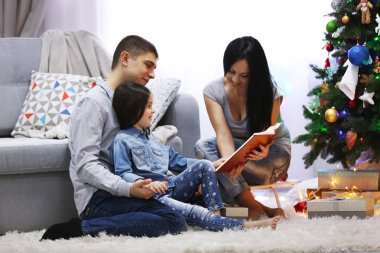 Mutlu aile dekore edilmiş Noel Oda kitap okumak