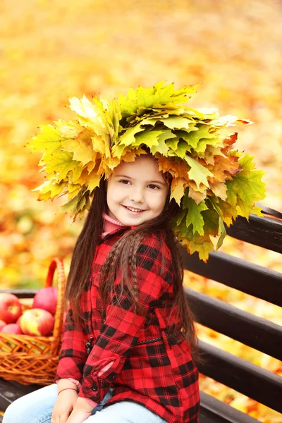 Happy young girl in yellow autumn wreath  in park — Stock Photo, Image