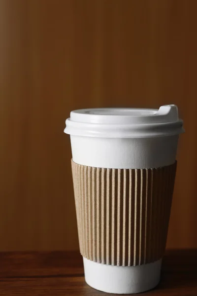 Papírový šálek kávy na stole, na dřevěné pozadí — Stock fotografie