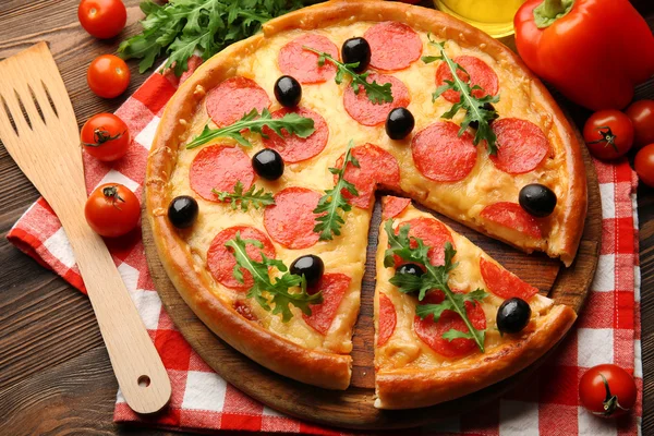 Deliciosa pizza saborosa com salame e azeitonas em fundo de madeira, close-up — Fotografia de Stock