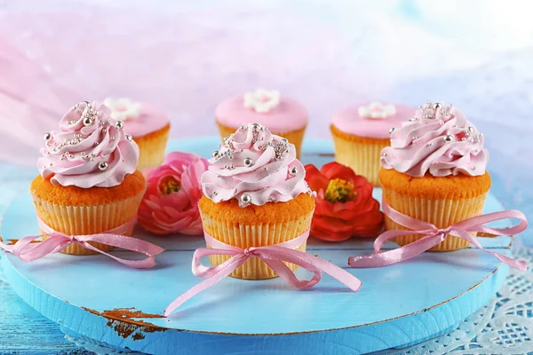 Νόστιμο cupcakes σε δίσκο, επάνω ελαφρύς υπόβαθρο — Φωτογραφία Αρχείου