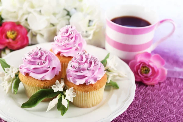 Gustosi cupcake su piatto, su fondo chiaro — Foto Stock