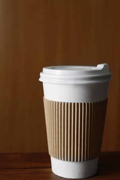 Paper cup of coffee on table, on wooden background — Stock Photo, Image