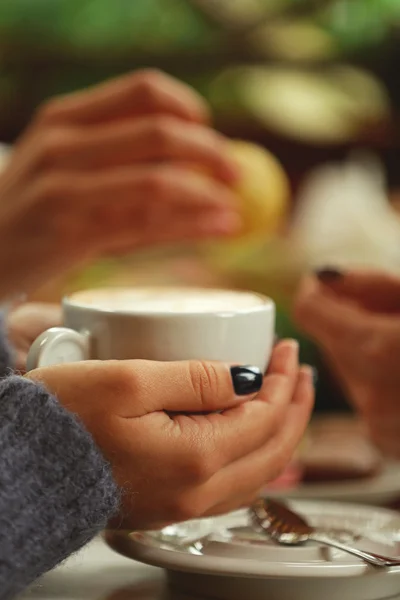 Kafede elinde kahve tutan bir kadın. — Stok fotoğraf