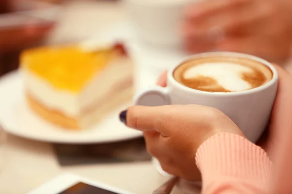 Mujer con una taza de café y pastel en la cafetería —  Fotos de Stock