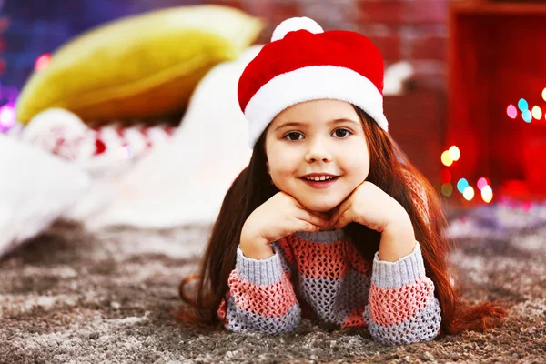 Hezká holčička v červeném klobouku v vánoční zdobené místnosti — Stock fotografie