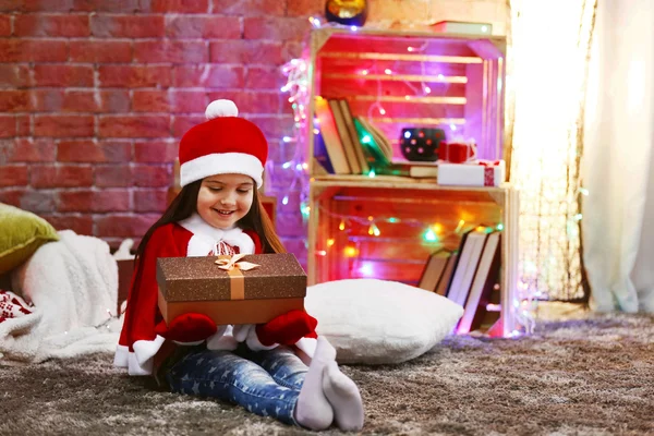 Vrij klein meisje in Carnaval kostuum zitten in Kerstmis ingericht kamer — Stockfoto
