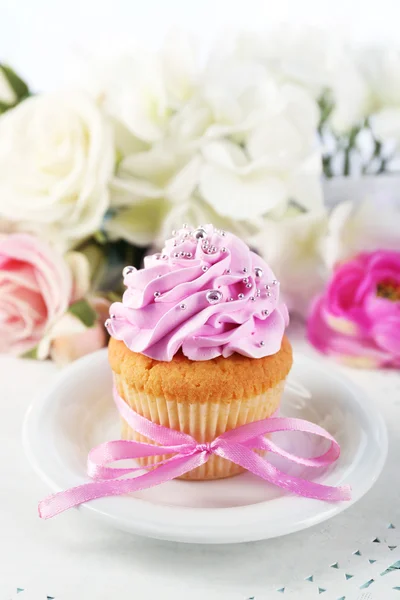 Tasty cupcake on plate, on light background — Stock Photo, Image