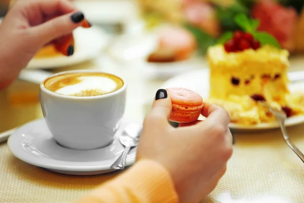 Mujer con una taza de café y galletas en la cafetería — Foto de Stock