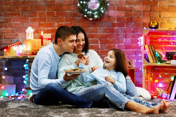 Família feliz com leite e biscoitos na sala de Natal decorada — Fotografia de Stock