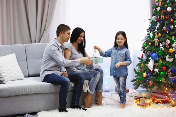 Famiglia amorevole: madre, padre e figlia nella stanza decorata di Natale — Foto Stock