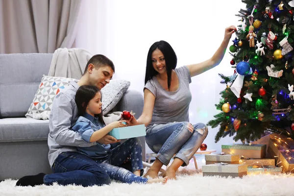 Familia feliz con regalos en la habitación de Navidad decorada —  Fotos de Stock