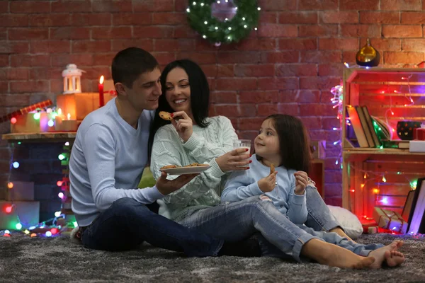 Familia feliz con leche y galletas en la sala de Navidad decorada —  Fotos de Stock