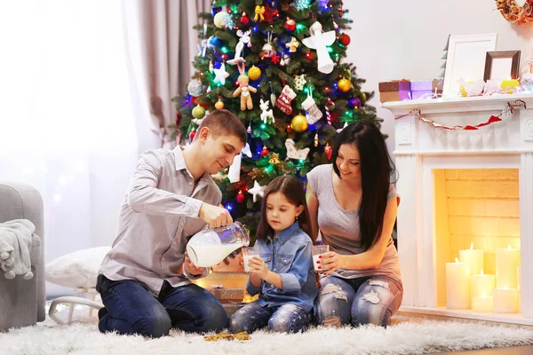 Felice famiglia bere latte nella stanza decorata di Natale — Foto Stock