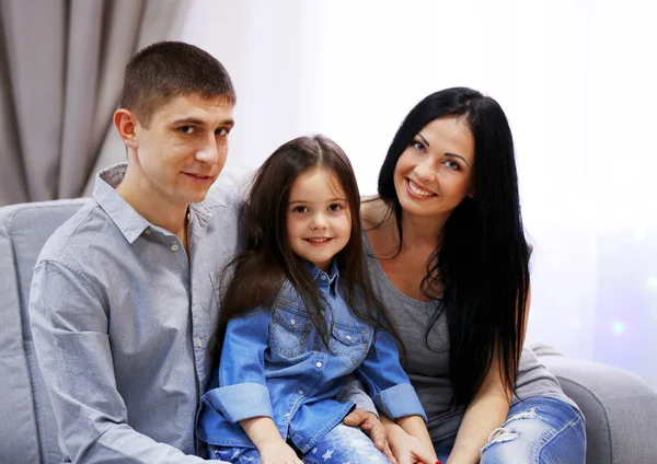 Família feliz sentada no sofá — Fotografia de Stock