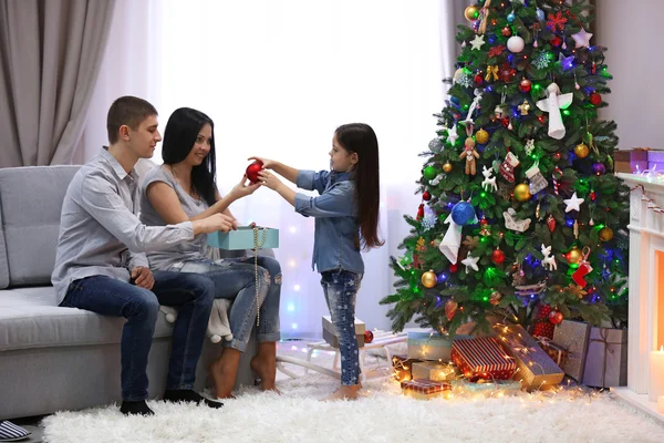 Familia cariñosa: madre, padre e hija en la habitación de Navidad decorada — Foto de Stock