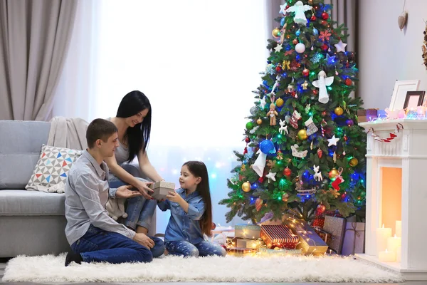 Familia cariñosa: madre, padre e hija en la habitación de Navidad decorada — Foto de Stock