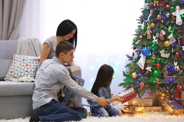 Joyeux famille avec des cadeaux dans la salle de Noël décorée — Photo