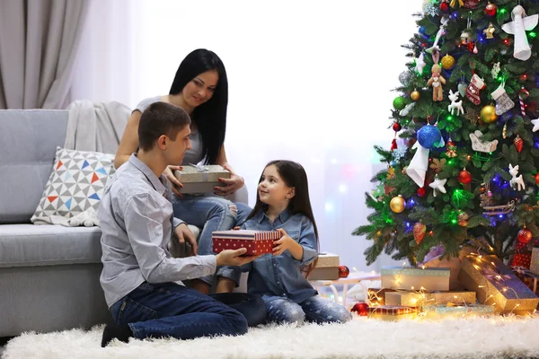 Familia feliz con regalos en la habitación de Navidad decorada — Foto de Stock