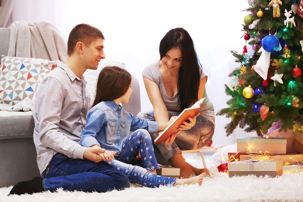 Lees boek in de ingerichte kamer voor Kerstmis en gelukkige familie — Stockfoto