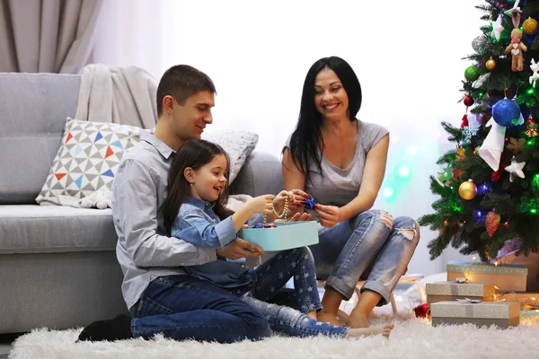 Familia feliz con regalos en la habitación de Navidad decorada —  Fotos de Stock