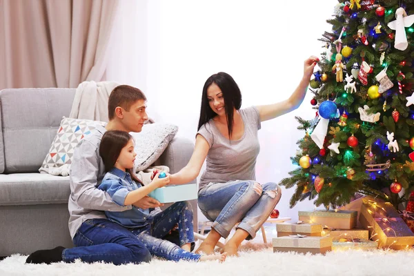 Lycklig familj med gåvor i den inredda jul rum — Stockfoto