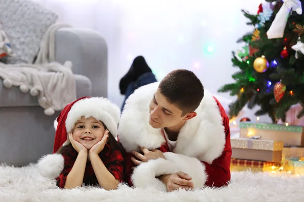 Gelukkig vader en dochter op de vloer in de ingerichte kamer voor Kerstmis — Stockfoto