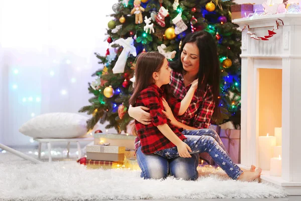 Y la hija sentada cerca de chimenea decorativa — Foto de Stock