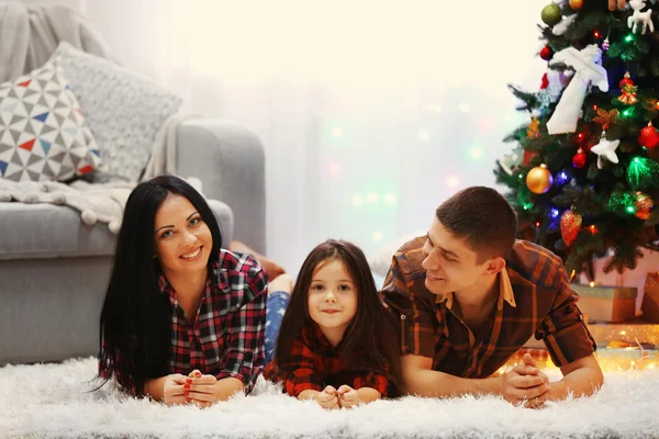 Familia feliz en el suelo en la habitación de Navidad decorada —  Fotos de Stock