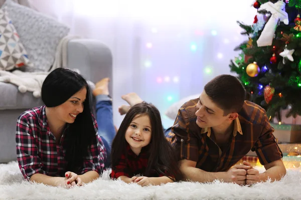 Família feliz no chão na sala de Natal decorada — Fotografia de Stock