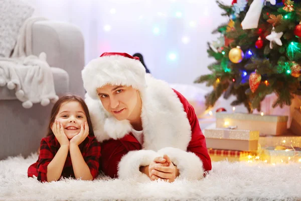 Gelukkig vader en dochter op de vloer in de ingerichte kamer voor Kerstmis — Stockfoto