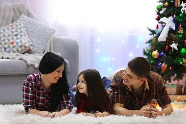 Famiglia felice sul pavimento nella stanza decorata di Natale — Foto Stock