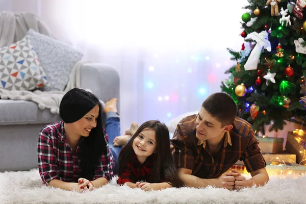 Familia feliz en el suelo en la habitación de Navidad decorada —  Fotos de Stock