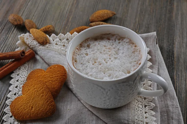 Kopp varm kakao på bomull servett med kanel, mandlar och hjärtat formad kakor — Stockfoto