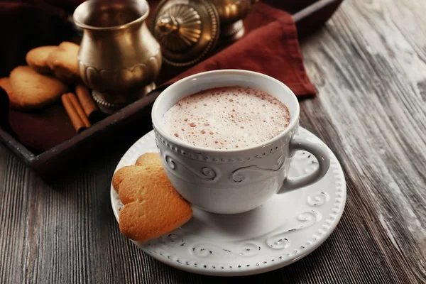 Copa vintage de cacao sobre mesa de madera contra bandeja con servicio de plata y galletas — Foto de Stock