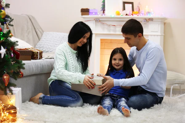 Familia feliz en el suelo con regalos en la habitación de Navidad decorada —  Fotos de Stock