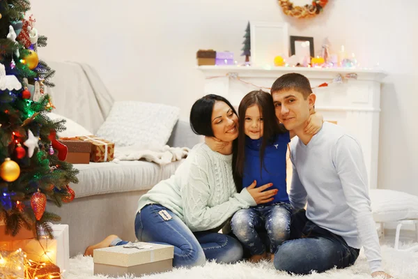 Joyeux famille sur le sol avec des cadeaux dans la salle de Noël décorée — Photo